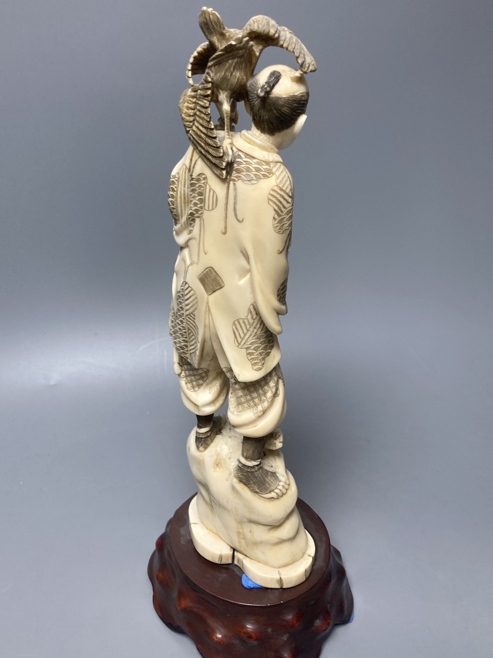 A Japanese walrus ivory okimono of a cormorant fisherman, early 20th century, overall height 34cm